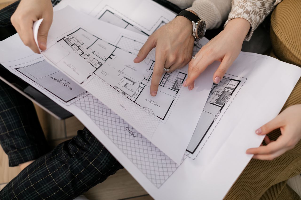 our-stories Two people examining architectural blueprints, focusing on project details.